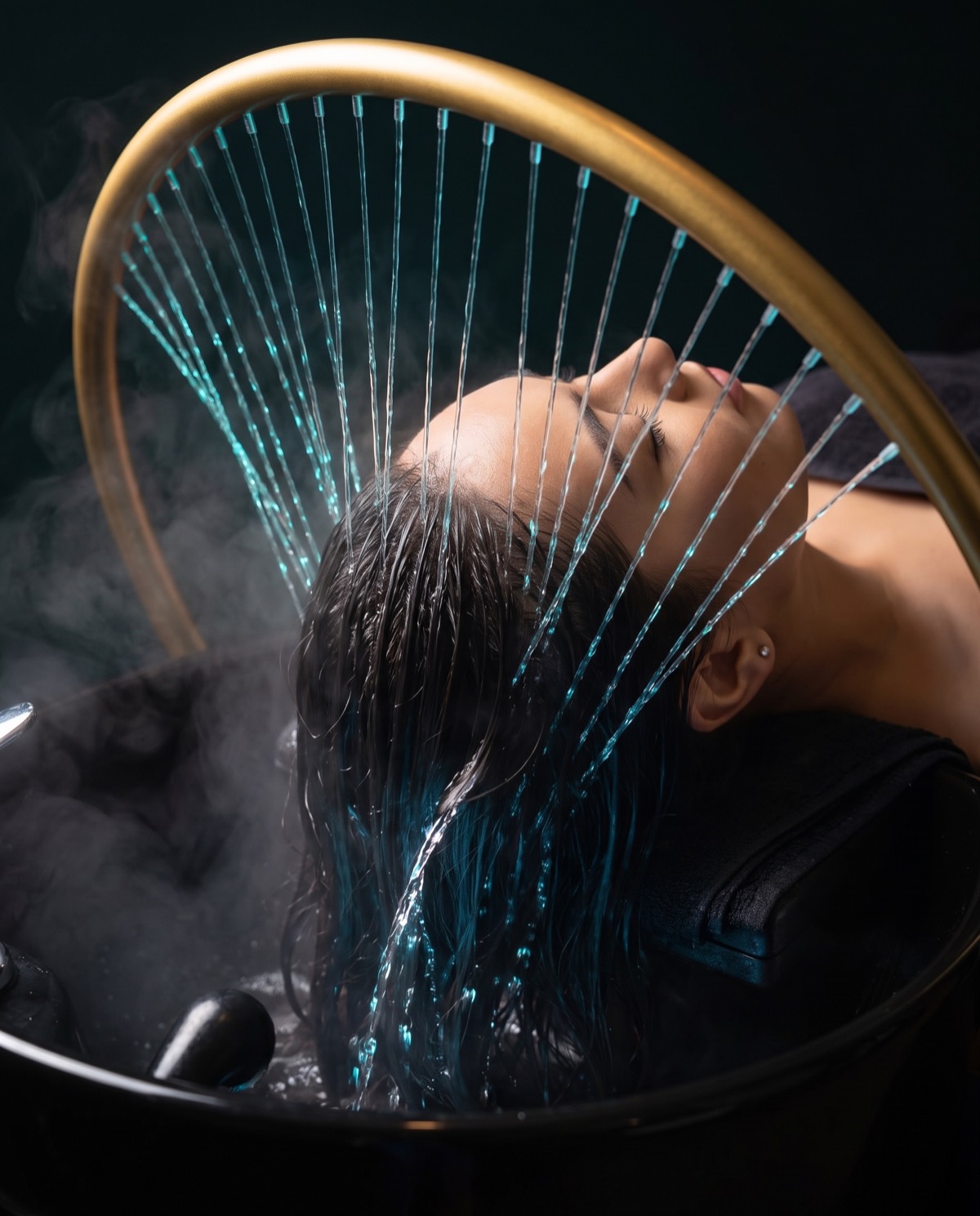 Guest relaxing during a Japanese head spa treatment under softly-lit water at Hair + SKN